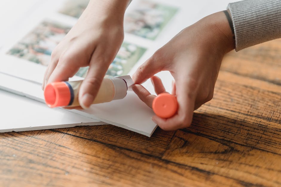 A person painting a wooden surface with glue, demonstrating the steps for achieving a professional finish when painting over wood glue.