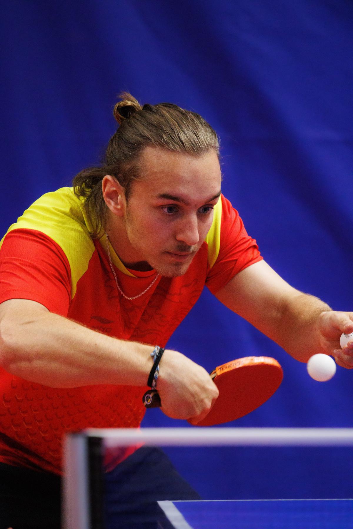 A person playing ping pong on a portable table top, demonstrating its versatility and convenience for different playing spaces and skill levels.